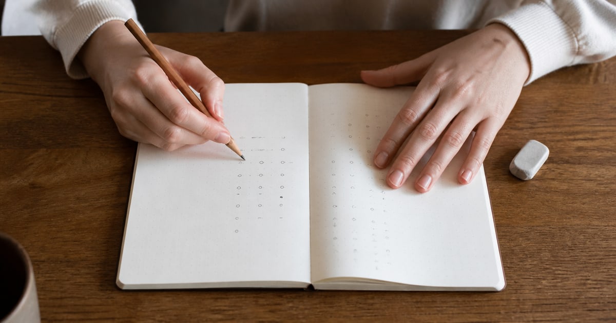 ノートに数字を書き出して計算する手元
